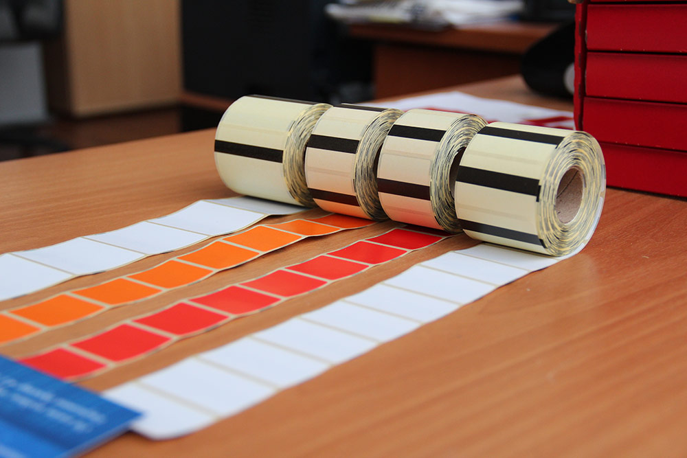 Четыре цветных рулонов этикеток на столе для принтеров Pathfinder