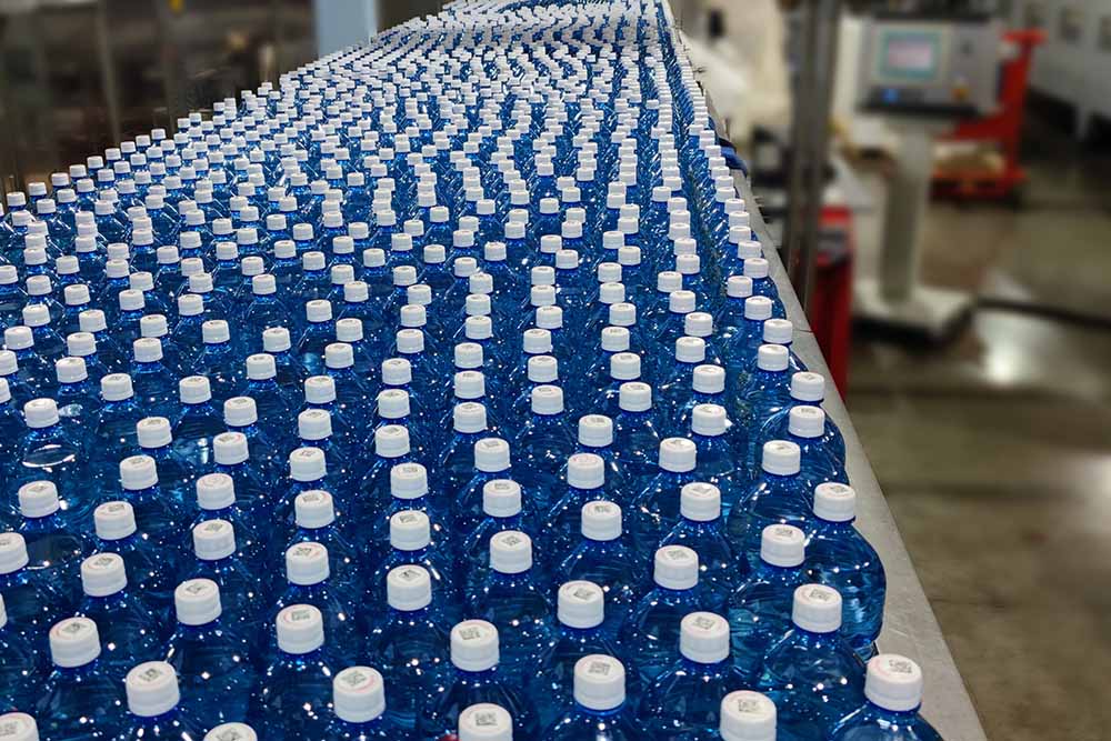 Поток пластиковых бутылок в цеху по производству воды