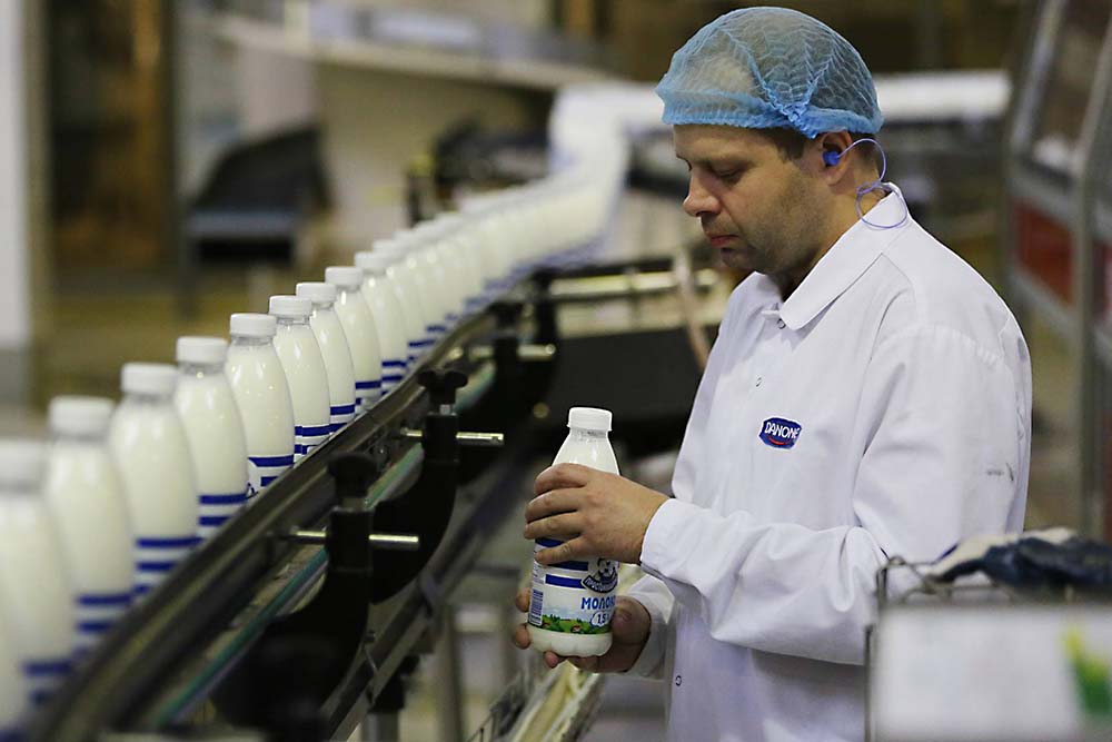 Сотрудник Danone у линии производства молока