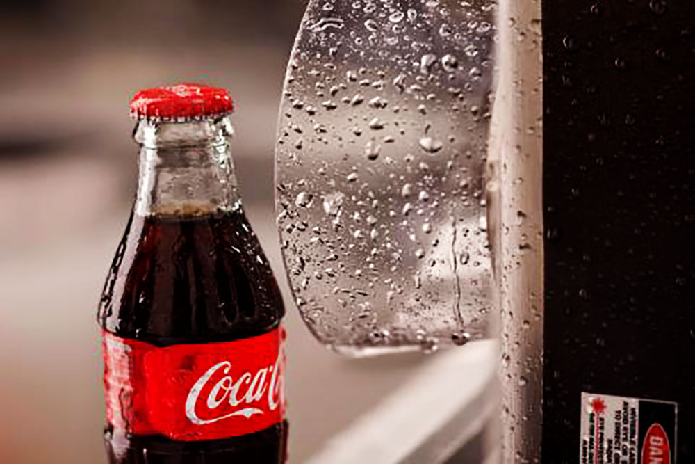 Пример маркировки даты лазером на бутылках Cola, движущихся по конвейеру в суровых условиях