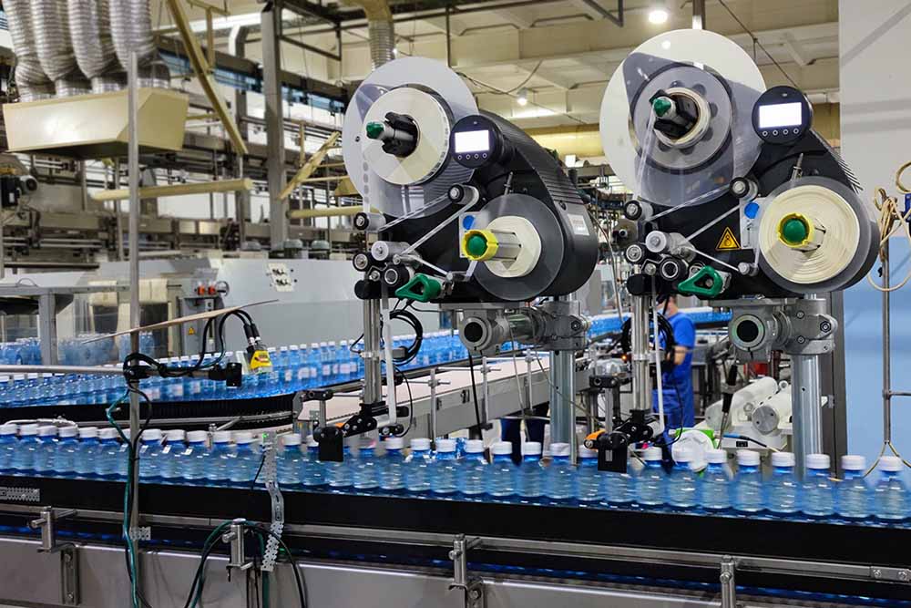 Этикетировщики Novexx XLS 2xx в рабочем режиме в цеху по производству питьевой воды